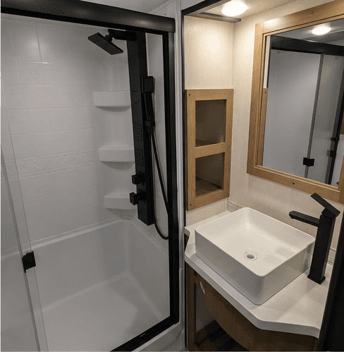 Full bathroom with a glass shower, vessel sink, and framed mirror