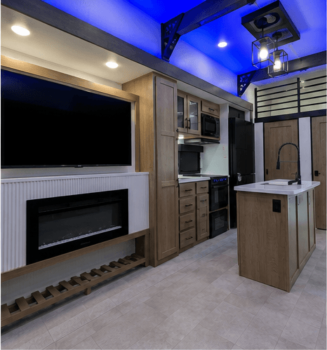 Electric fireplace below a wall-mounted television, with the kitchen and pantry beyond