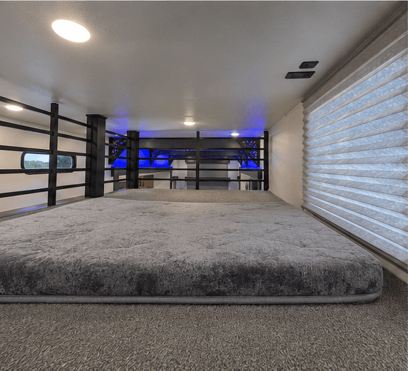 Double loft sleeping platform above the main living area, with a window at the end