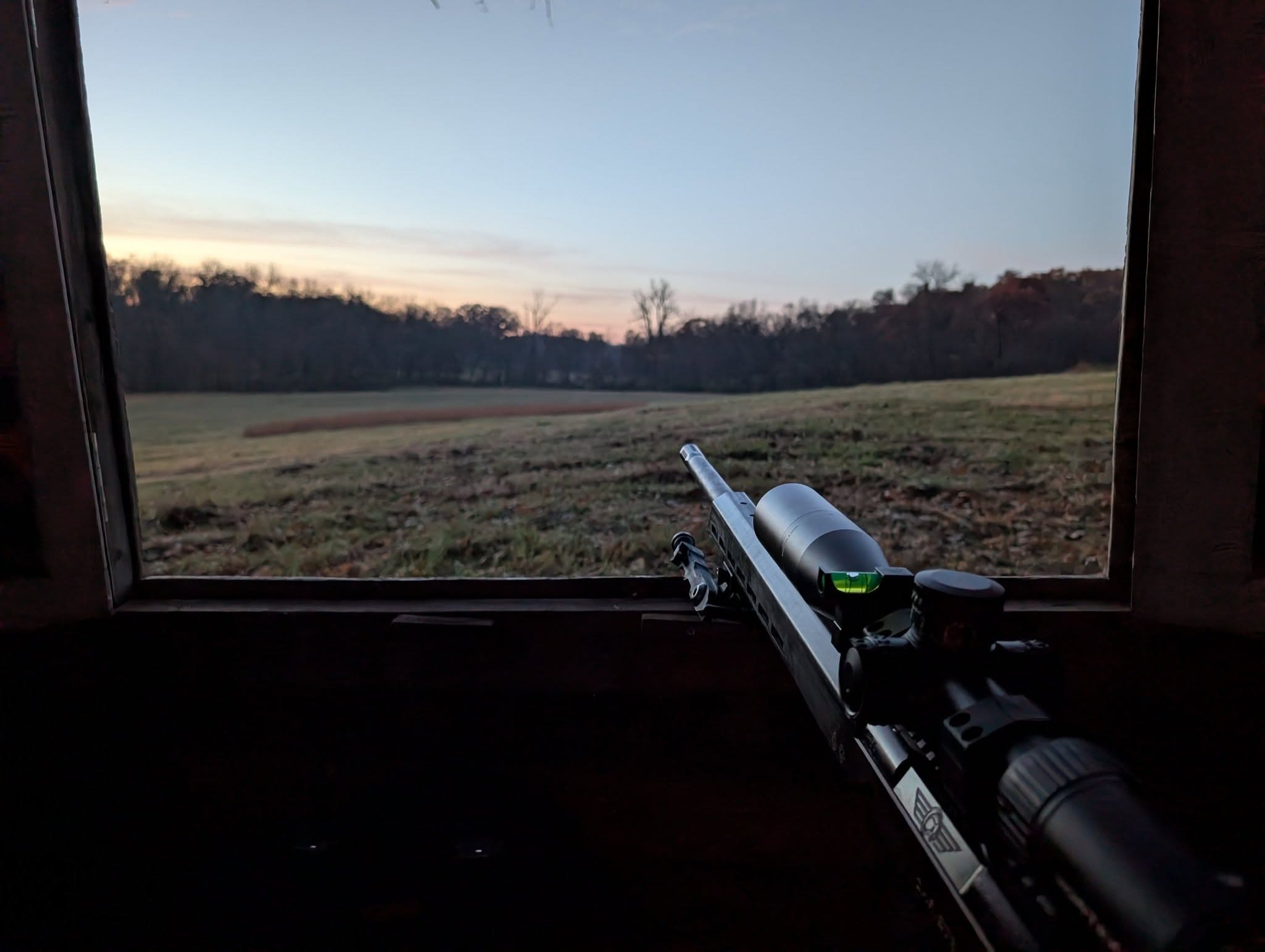View across a field from inside a deer blind at dawn