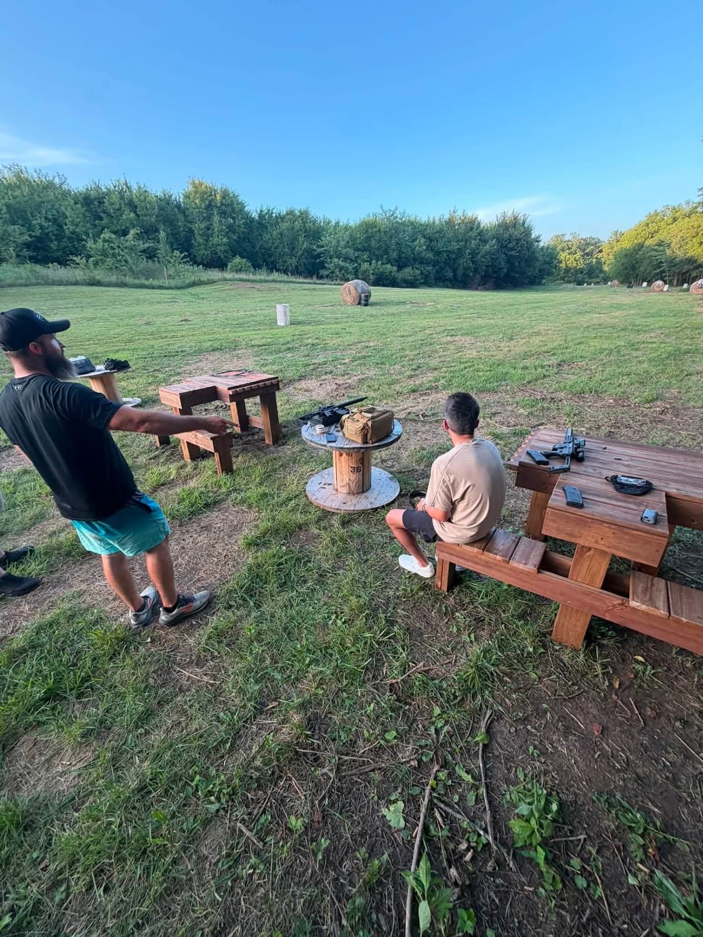 A member pointing out the target line to another member seated at the bench