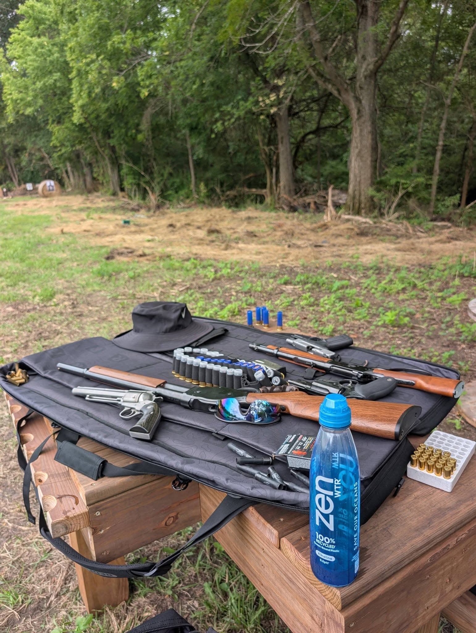 Handguns and a rifle staged on a range table