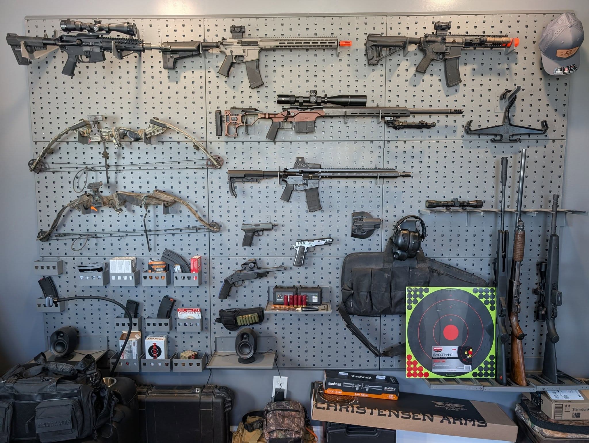Wall-mounted rack of rifles, bows, and gear